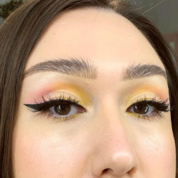 A woman wearing yellow and pink eyeshadow