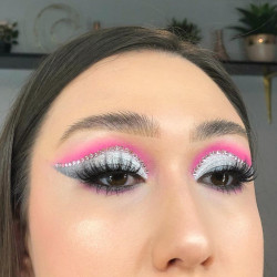 A woman wearing silver and pink eyeshadow with gemstones